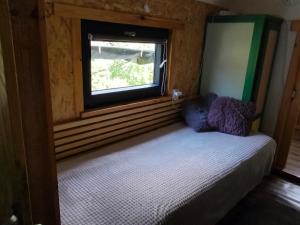a small bed in a room with a window at Domek Drzymały in Maków