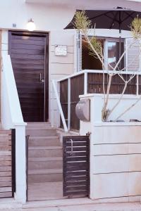 una puerta delantera de una casa con escaleras y sombrilla en Casa los pececitos, en Carboneras