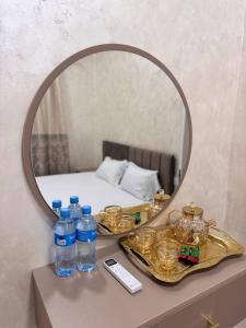a mirror on top of a table with water bottles at Home Hotel in Toshkent-Passajir Bekati