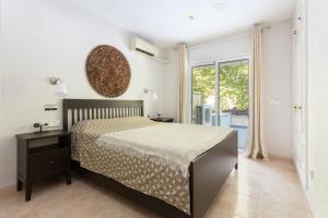 a bedroom with a bed and a large window at SeaBreezeHeaven - Sea View Apartment, Pool & Spacious Terrace with BBQ - 50m from Sant Pol Beach in Sant Feliu de Guixols