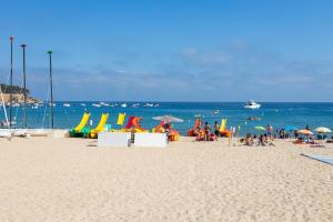 a group of people on a beach with the ocean at SeaBreezeHeaven - Sea View Apartment, Pool & Spacious Terrace with BBQ - 50m from Sant Pol Beach in Sant Feliu de Guixols +44 photos