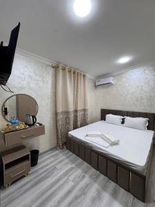 a bedroom with a large bed and a mirror at Home Hotel in Toshkent-Passajir Bekati
