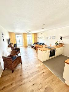 eine große Küche und ein Wohnzimmer mit Holzböden in der Unterkunft Haus Strandeck Apartment Meeresrauschen 12 in Göhren