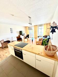 eine Küche mit einer Arbeitsplatte und ein Wohnzimmer in der Unterkunft Haus Strandeck Apartment Meeresrauschen 12 in Göhren + 19 Fotos