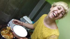 a woman is holding a pot of food at Villa Butterfly Studio in Pondicherry
