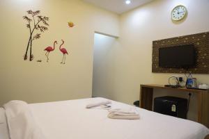a hotel room with a bed and a tv at Maitri Retreat in Panchgani