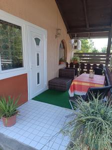 a patio with a table and chairs on a house at Tulman Apartment in Balatonberény