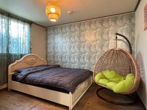 a bedroom with a rattan bed and a chair at Daegu Stay Hoya in Daegu +8 photos