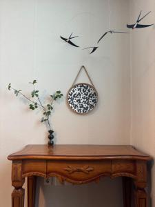 a table with a mirror and birds on the wall at Daegu Stay Hoya in Daegu