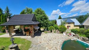 a garden with a gazebo and a pond at Agroturystyka na szlaku in Lubomierz