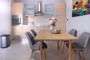 Una cocina y un comedor con mesa y sillas de madera. en NIDO Apartments, en Pučišća