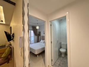 a bathroom with a bed and a toilet in a room at Aura Douce Appartement in Martil +8 photos