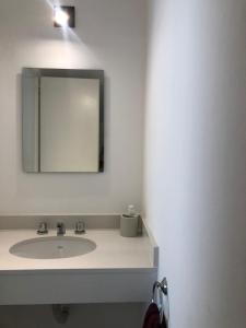 a bathroom with a sink and a mirror at Duplex en alquiler in Tandil