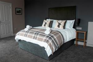 a bedroom with a large bed with stuffed animals on it at Guardbridge Inn in St. Andrews