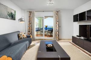 a living room with a blue couch and a coffee table at La Noria de Julie in San Luis de Sabinillas