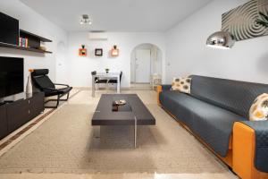 a living room with a couch and a table at La Noria de Julie in San Luis de Sabinillas +42 photos