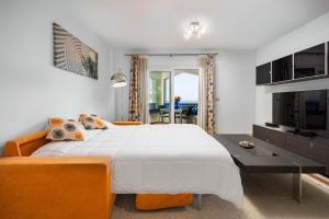 a bedroom with a large white bed and orange furniture at La Noria de Julie in San Luis de Sabinillas