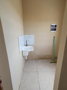 a bathroom with a white sink in a room at Casa de locação in Goiana