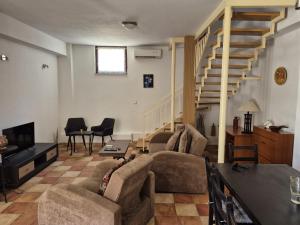 a living room with a couch and a staircase at Stone house Pietro in Pakoštane