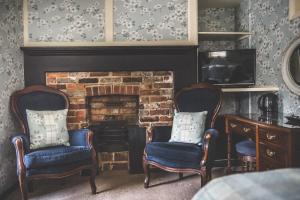 a living room with two chairs and a fireplace at Jeakes House in Rye
