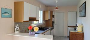 a kitchen with a vase of flowers on a counter at Maison 5 chambres, 3 SdB, proche plage in Arzon