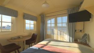 a bedroom with a bed and a table and window at Shepherd's Hut in Badluchrach
