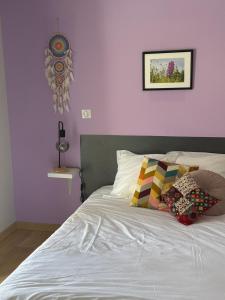 Un dormitorio con una cama blanca con paredes moradas en Gîte Bortü Lilia, en Aroue 2 fotos más