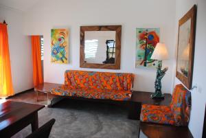 a living room with an orange couch and a mirror at villa Erica bella vista in Hell-Ville