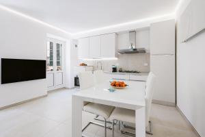 a white kitchen with a white table and chairs at Paradise House - Shell in Noli
