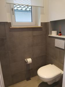a bathroom with a toilet and a window at Renovierte Wohnung zentral in Lemgo in Lemgo +4 photos