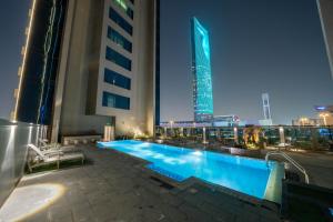 a swimming pool on the roof of a building at night at DAMAC Royal Two Bedroom Apartment Al Olaya in Riyadh +15 photos