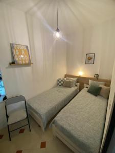 a bedroom with two beds and a chair in it at Apartament Hana in Golem
