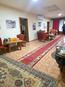 a living room with chairs and a table and a rug at Zuta kuca in Svilajnac