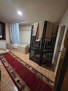 a bathroom with a tub and a towel rack at Zuta kuca in Svilajnac +8 photos