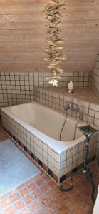 a bath tub in a room with a wooden wall at Haus Sonnhof in Herzogau +18 photos