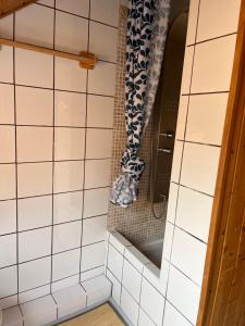 a bathroom with white tiled walls and a mirror at La Cerveyrette in Cervières