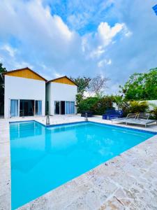 a swimming pool in front of a house at Cabaña en punta cana in Punta Cana