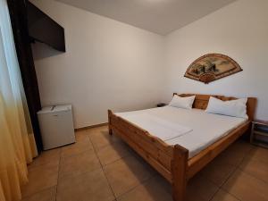 a bedroom with a wooden bed with white sheets at Casa Nicolas in Costinesti +31 photos