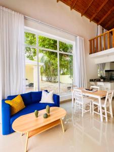 a living room with a blue couch and a table at Cabaña en punta cana in Punta Cana