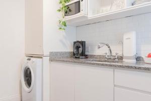 une cuisine blanche avec un évier et une machine à laver dans l'établissement Fliphaus Ravignani 2200 - Vintage Villa Palermo Hollywood, à Buenos Aires