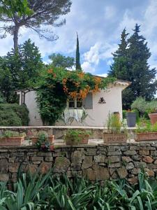a house with flowers on a stone wall at Le Mazet du Lapin Rouge in Figanières