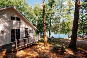 a small white house with a porch and a picnic table at "Cabin Fever" on Arbutus Lake in Traverse City