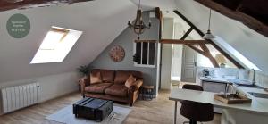 a living room with a couch and a table at Les Bras de Morphée in Avize