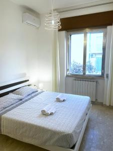 ein weißes Schlafzimmer mit einem Bett mit Handtüchern darauf in der Unterkunft Bouganville in Ginosa Marina