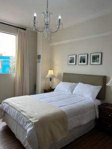 Un dormitorio con una gran cama blanca y una lámpara de araña. en Hotel Kon-tiki, en Lima 16 fotos más