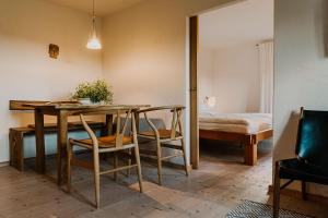 a dining room with a table and chairs and a bed at Haidl-Madl Ferien und Wohnen in Haidmühle