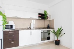 a kitchen with white cabinets and a microwave at Fliphaus Ravignani 1200 - Lux 1 Bd Pool Palermo Hollywood in Buenos Aires +4 photos
