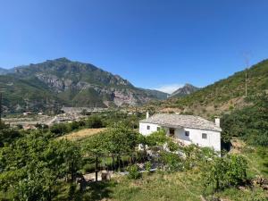una casa su una collina con le montagne sullo sfondo di Guest House Noku a Koman