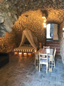 a room with a table and a bed in a stone wall at La Grotta in Pastrengo