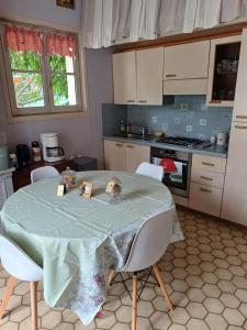 a kitchen with a table with chairs and a table cloth at Le Mazet du Lapin Rouge in Figanières